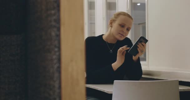 Vrouw in café SMS op mobiel — Stockvideo