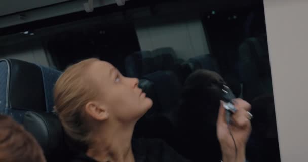 Vrouw commuter opladen van mobiele telefoon in de trein — Stockvideo