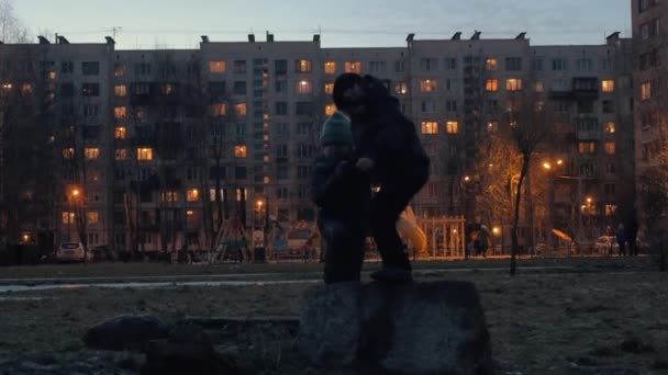 Fiú játszik együtt, ház udvarán, esti séta során — Stock videók