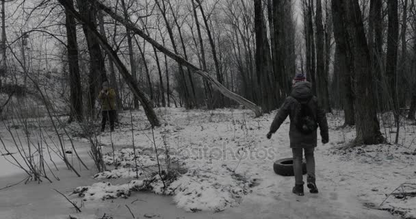 Natáčení videa teen boy odnášet pneumatiky z cesty v parku — Stock video