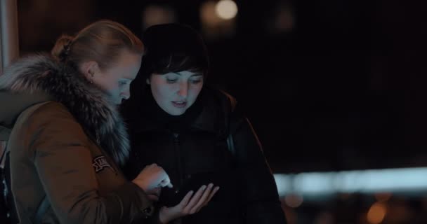 Женщины с цифровым планшетом на вечерней улице — стоковое видео