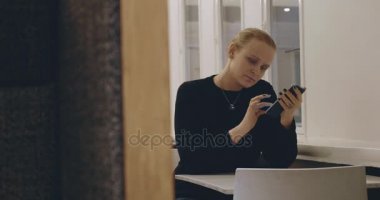 Kadın cep telefonundan mesaj yazarak Cafe
