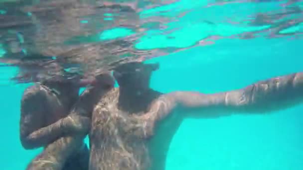 Дитина і батько махають руками під час дайвінгу в басейні — стокове відео