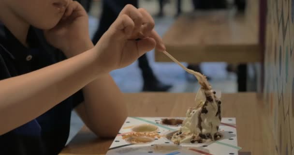 Niño comiendo helado en patio de comidas del centro comercial — Vídeos de Stock