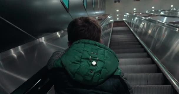 Pojke som flyttar upp på rulltrappan i tunnelbanan — Stockvideo