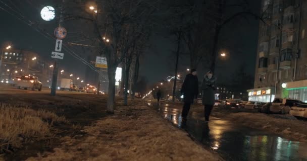 Ciudad nocturna con tráfico de coches y mujeres amigas caminando por la calle — Vídeo de stock