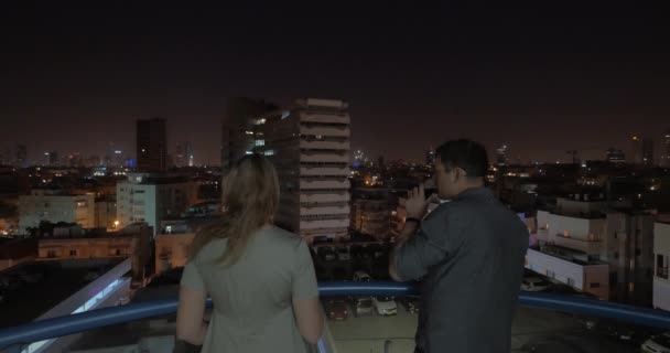 Hombre y mujer mirando la noche Tel Aviv desde el techo del hotel, Israel — Vídeos de Stock