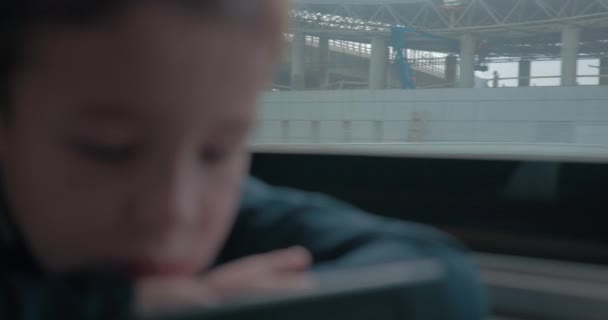 Niño en tren entretenido con dibujos animados en el teléfono celular — Vídeo de stock