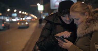Mobil akşam otobüs durağında beklerken bir şey izlerken kadın