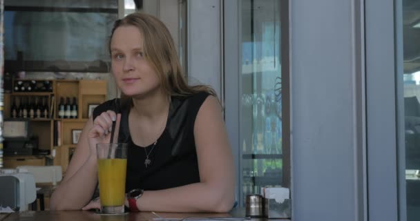 Mujer con mirada melancólica teniendo jugo en la cafetería — Vídeo de stock