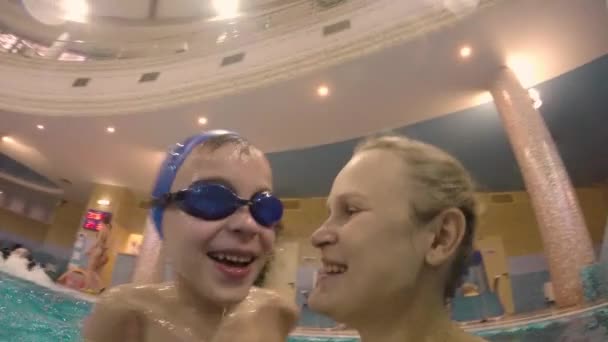 Menino ter bom tempo com a mãe no parque aquático — Vídeo de Stock