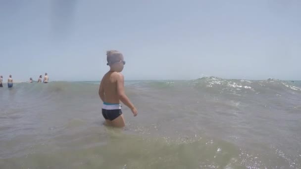 Niño bañándose en el mar en el caluroso día de verano — Vídeos de Stock