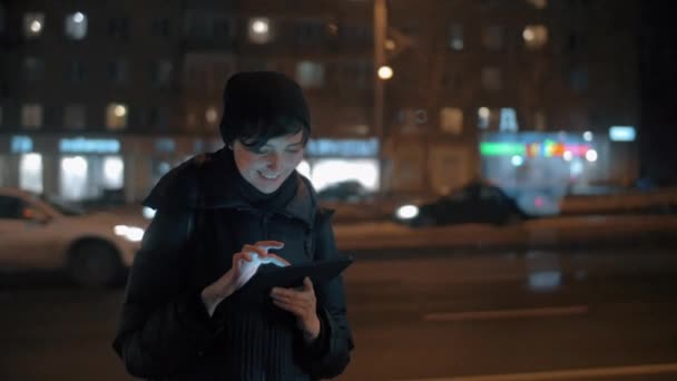 Jonge vrouw met digitale tablet in avond stad — Stockvideo