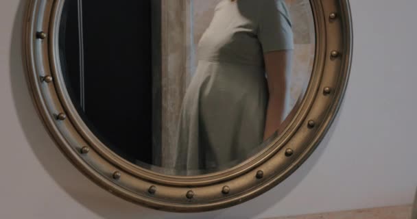 Femme enceinte regardant miroir et caresser le ventre — Video