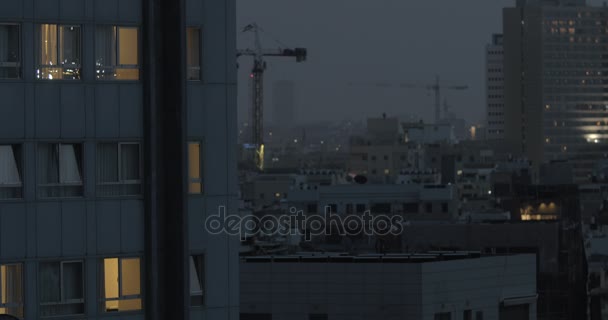 Večerní pohled na Tel Aviv s domy a jeřáby, Izrael
