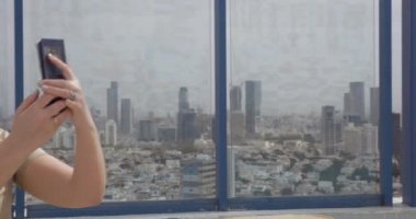Gülümseyen kadın yüksekliği görünümünden Tel Aviv karşı cep fotoğraf yapma