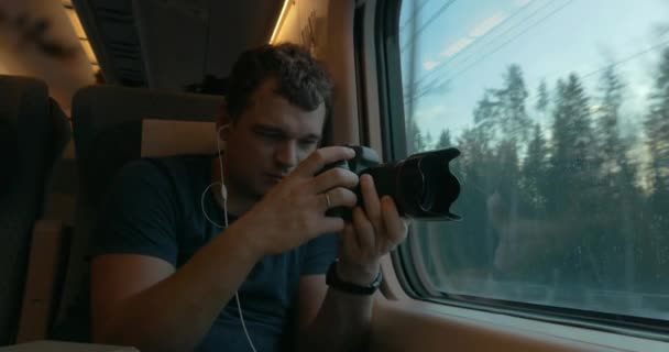 Man stocker in train listening to music and making footage — Stock Video