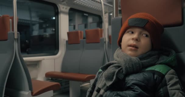 Chłopiec w ruchu podmiejskim pociągiem w nocy — Wideo stockowe