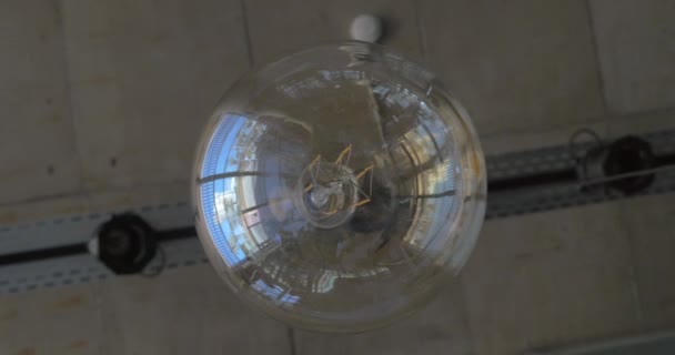 Стеклянная лампа шара висит на потолке — стоковое видео