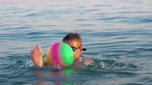 Barn leker med bollen när du badar i havet på semester — Stockvideo