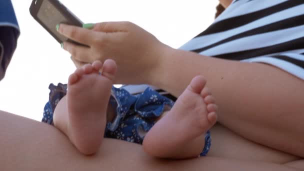 Mujer usando el teléfono celular mientras el bebé duerme — Vídeo de stock