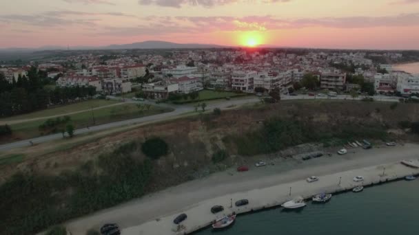 Fliegen bei Sonnenuntergang über den Kai und die Hausdächer. nea kallikratia, Griechenland — Stockvideo