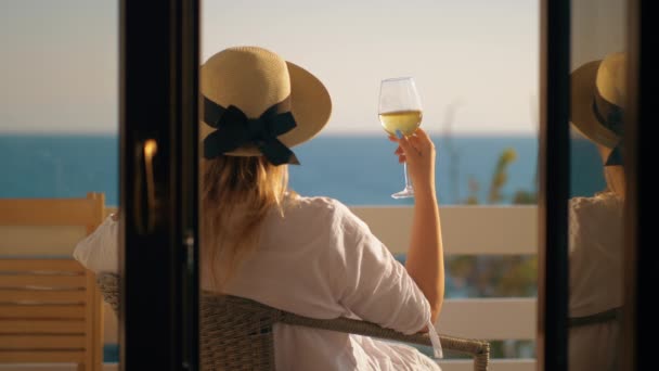 Mujer pasando un buen rato bebiendo vino en el balcón con vistas al mar — Vídeo de stock