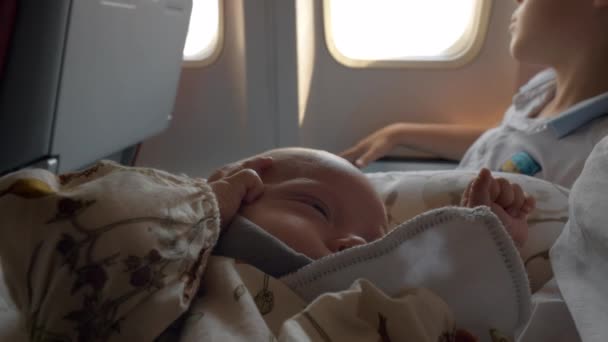 Дитина літає на літаку з сім'єю і прокидається після гарного сну — стокове відео