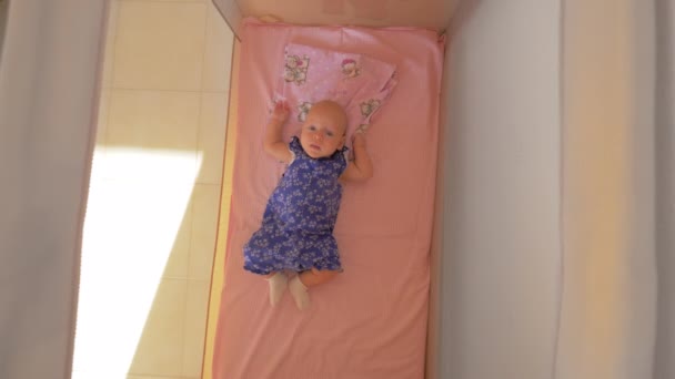 Trzech miesięcy dziewczynka leżąc w kojcu — Wideo stockowe
