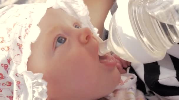 Мать дает девочке пить из бутылки — стоковое видео