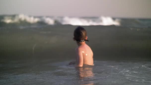 Niño bañándose en el mar y las olas lo golpearon — Vídeos de Stock