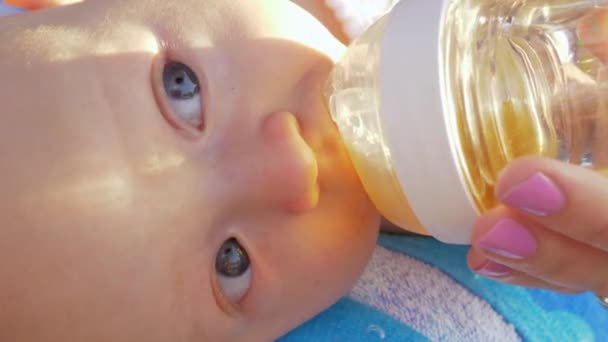 Baby girl drinking from bottle outdoor — Stock Video
