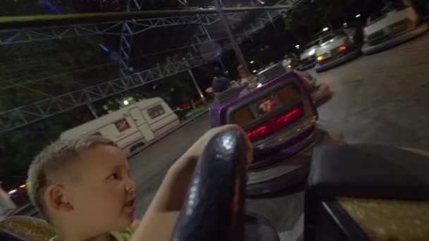 Kinderen hebben goede tijd op de kermis bij het rijden van de botsauto 's — Stockvideo