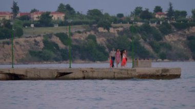 İnsanların akşam Yunanistan iskelede yürüyüş