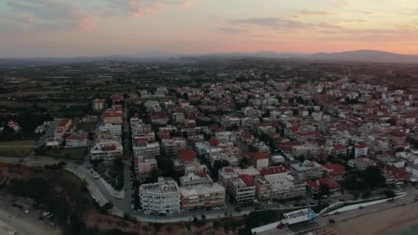 Vliegen over de huizen daken in de kustplaats, zonsopgang scène. Nea Kallikratia, Griekenland — Stockvideo
