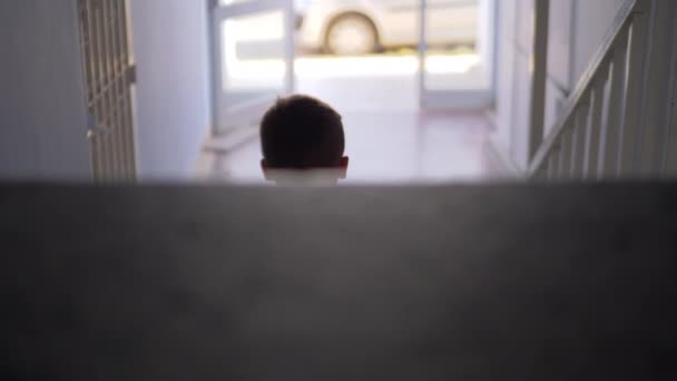 Miúdo sentado sozinho nas escadas — Vídeo de Stock