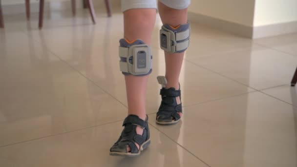 Терапия с функциональной электрической стимуляцией. Ребенок носит систему опускания ног — стоковое видео