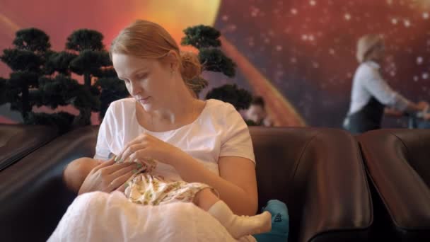 Vrouw borstvoeding baby in luchthaven lounge — Stockvideo