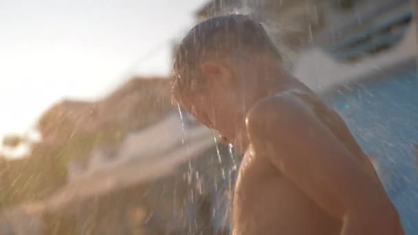 El niño está bajo una ducha de playa fresca al aire libre — Vídeos de Stock