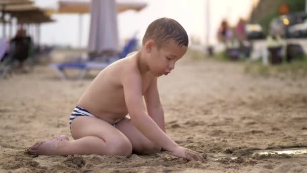 Kid hrát s pískem pláži během letních prázdnin — Stock video