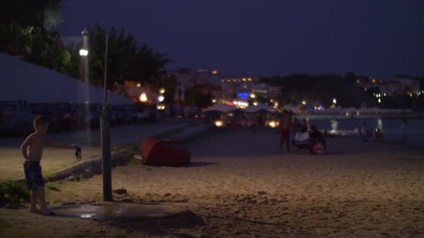 Pláž s lidmi v letovisko v noci, Řecko — Stock video