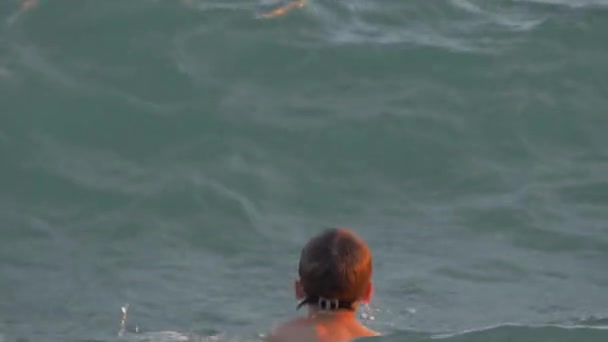 Kind zwemmen in de zee en het vangen van sterke golven — Stockvideo