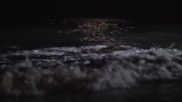 Dunkle schäumende Wellen, die nachts die Küste spülen — Stockvideo