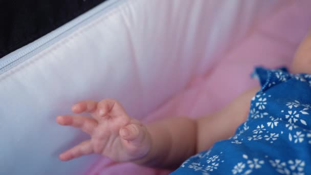 Baby in kinderwagen verplaatsen van haar hand — Stockvideo