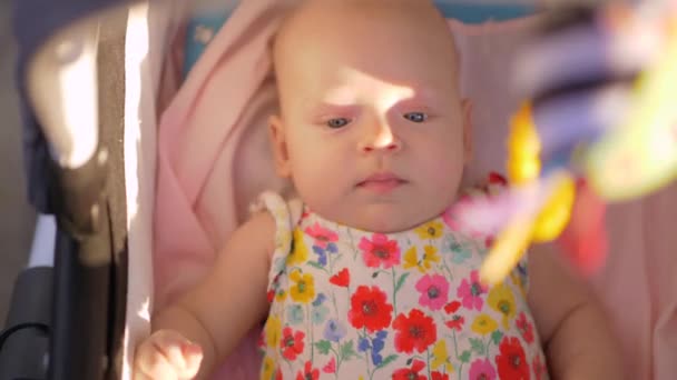 Meisje van de actieve baby in de kinderwagen buiten — Stockvideo