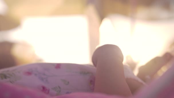 Baby bewegliche Hände, Blick in die Abendsonne — Stockvideo