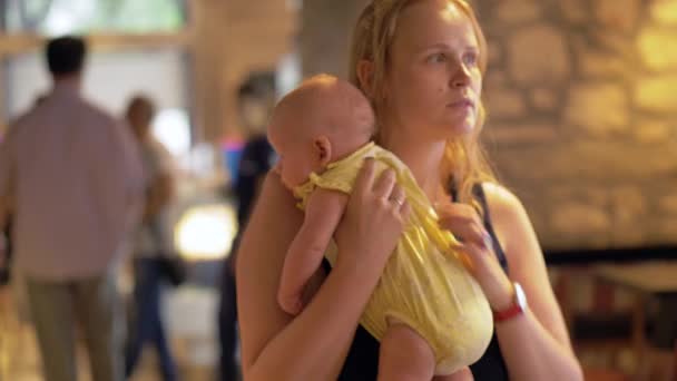Vrouw met ondeugende baby in café — Stockvideo