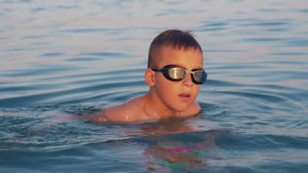 Niño con bola bañándose en el mar — Vídeo de stock