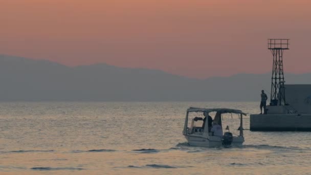 Łodzi motorowych pływających w spokojne morze w pobliżu nabrzeża, wieczór scena — Wideo stockowe
