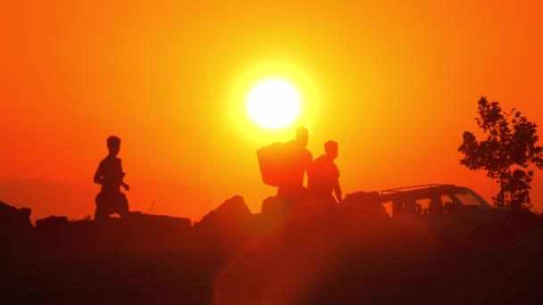 Люди уходят с пляжа на закате — стоковое видео